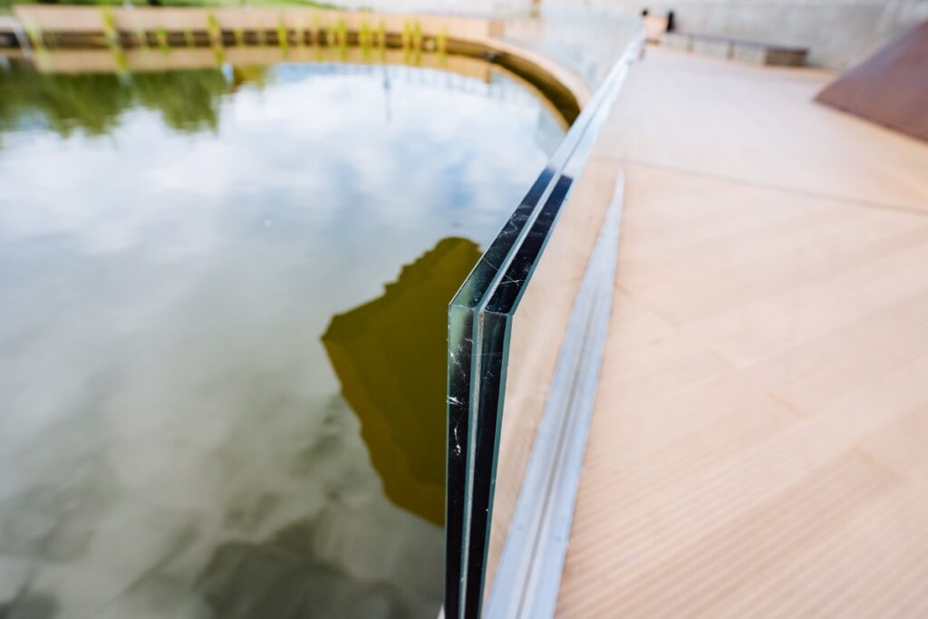 modern glass balustrade stands elegantly over a tranquil water surface